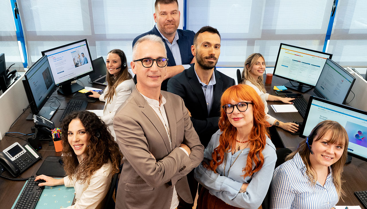 Il Team Ehiweb in ufficio: al centro Luigi, Simona, Matteo e Gilberto, sedute ai computer Michela. Tatiana, Carlotta e Arianna